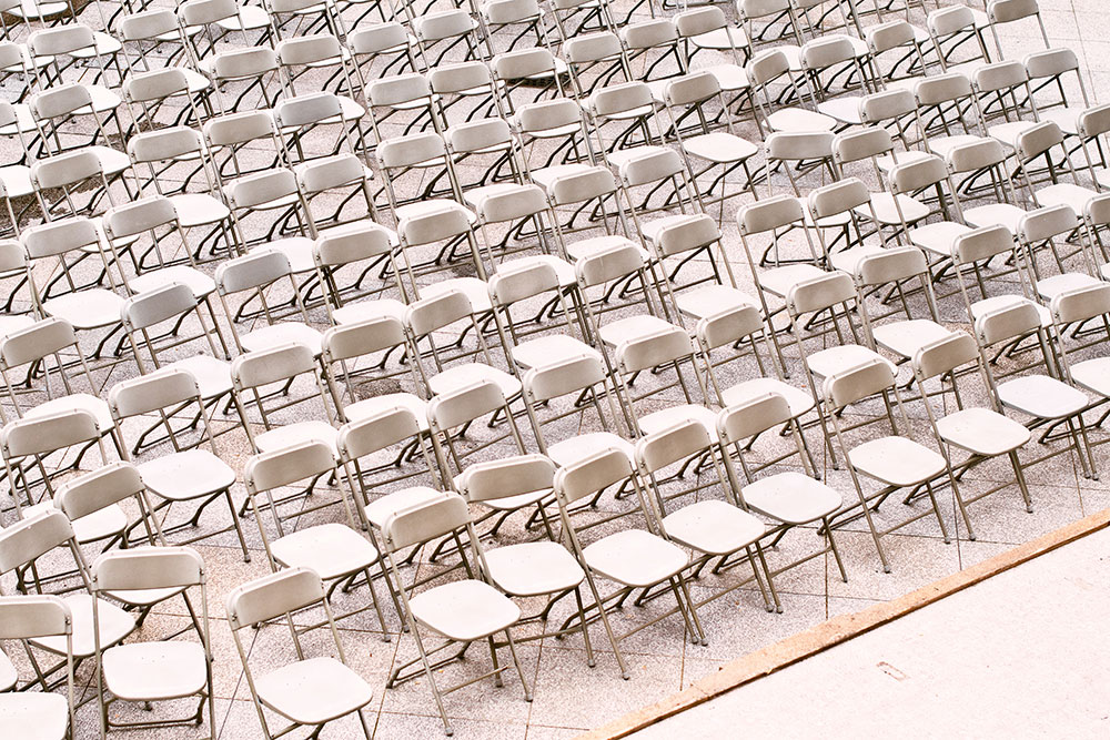 Стулья в ряд. Ряд белых стульев. Много стульев в ряд одинаковых. Мешки стулья в школе.